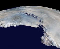 Satellite view of the icy landscape and mountains of Antarctica, showcasing the continent's extensive ice formations and rugged terrain.